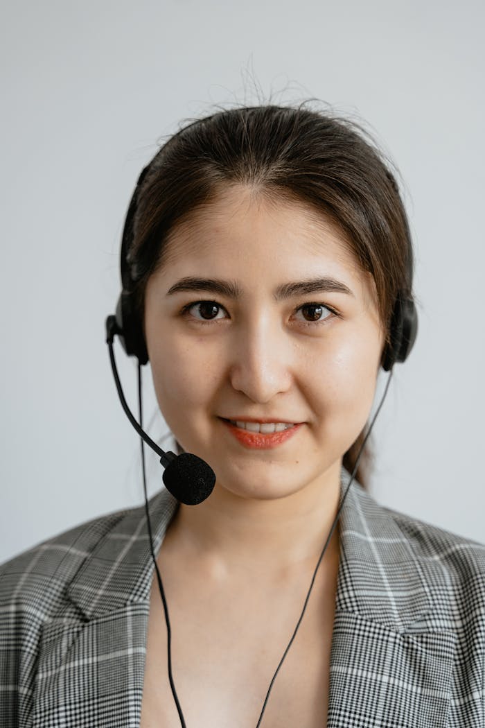 Smiling female call center agent wearing a headset, providing customer support.